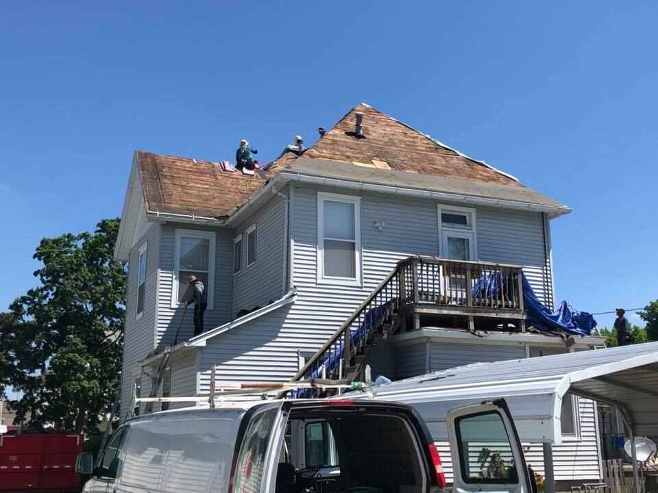 home roof replacement with team on roof